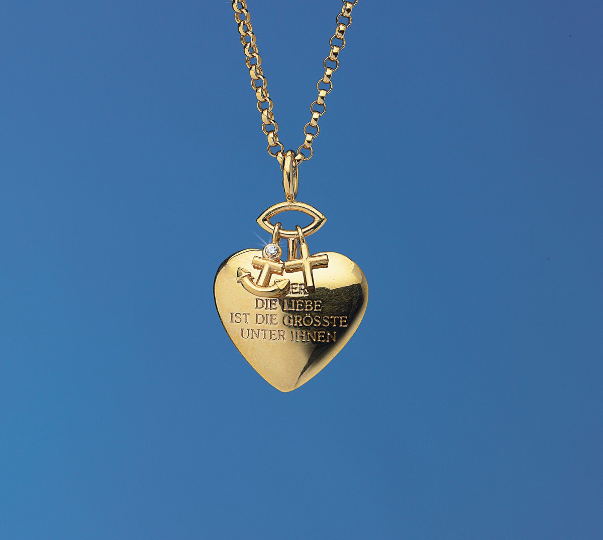 Goldene Herz-Kette mit den Symbolen Kreuz, Anker und Herz, sowie der Gravur 'Die Liebe ist die größte unter ihnen', auf einem blauen Hintergrund.