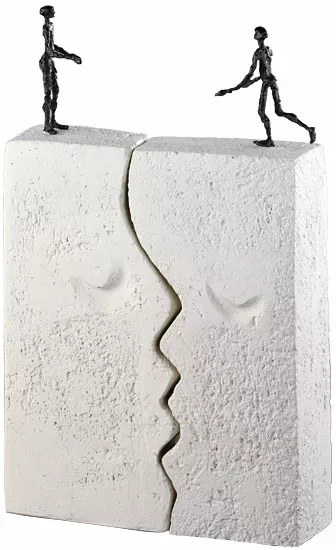 Eine abstrakte Skulptur von Luise Kött-Gärtner mit dem Titel 'Sehnsucht', bestehend aus zwei weißen, zementähnlichen Blöcken, die ein Gesicht und zwei schwarze Figuren, die auf ihnen stehen, darstellen.