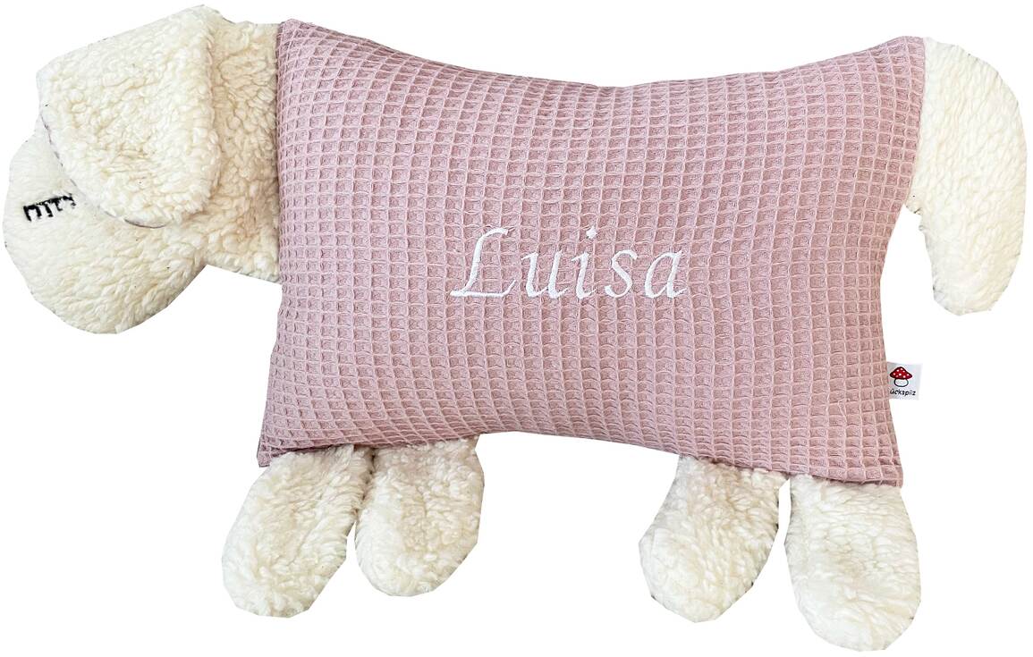 Ein Kuscheltierkissen in Form eines Schafes mit weißem Plüschkörper und einem rosa Kissenrücken, der in einem waffelmusterartigen Stoff gestaltet ist. Der Name 'Luisa' ist in weißer Schrift auf dem rosa Teil des Kissens gestickt.