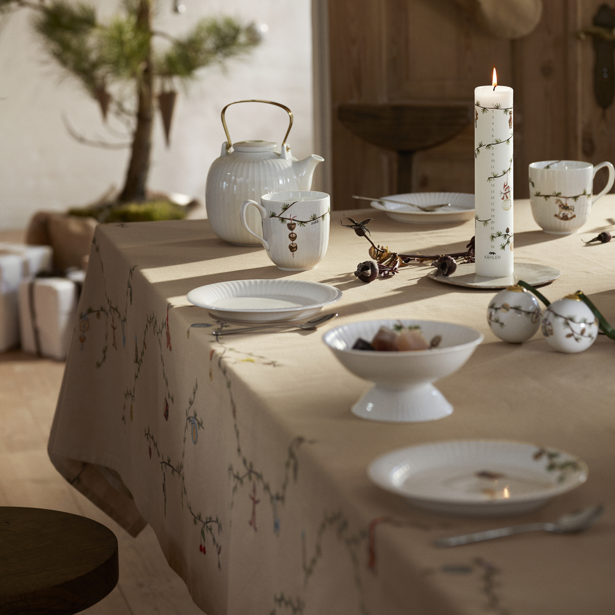 Beigefarbene Tischdecke der Serie Hammershøi auf einem festlich gedeckten Tisch, weihnachtlich dekoriert mit Kerzen, Porzellan und Tannenzweigen in einem skandinavischen Esszimmer.