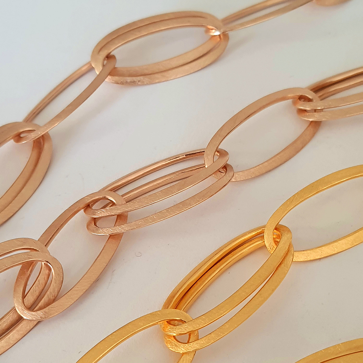 Das Bild zeigt drei elegante Gliederketten des Colliers »GRACE« von HML Berlin, gefertigt aus hochwertigem 925er Silber in den Varianten feingoldplattiert und roségoldplattiert. Die ovale, zeitlos-puristische Formensprache wirkt modern und sinnlich auf hellem Hintergrund.
