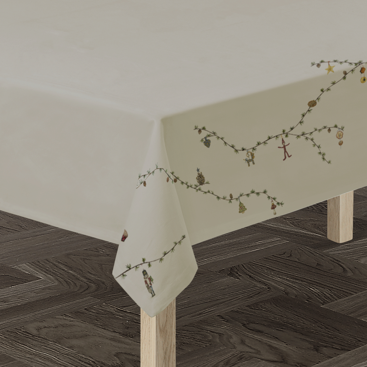 Beigefarbene Tischdecke mit zartem Blumen- und Naturmuster, drapiert über einen rechteckigen Holztisch auf dunklem Holzboden. Die Tischdecke verleiht dem Raum eine elegante und freundliche Atmosphäre und eignet sich besonders für festliche oder familiäre Anlässe.