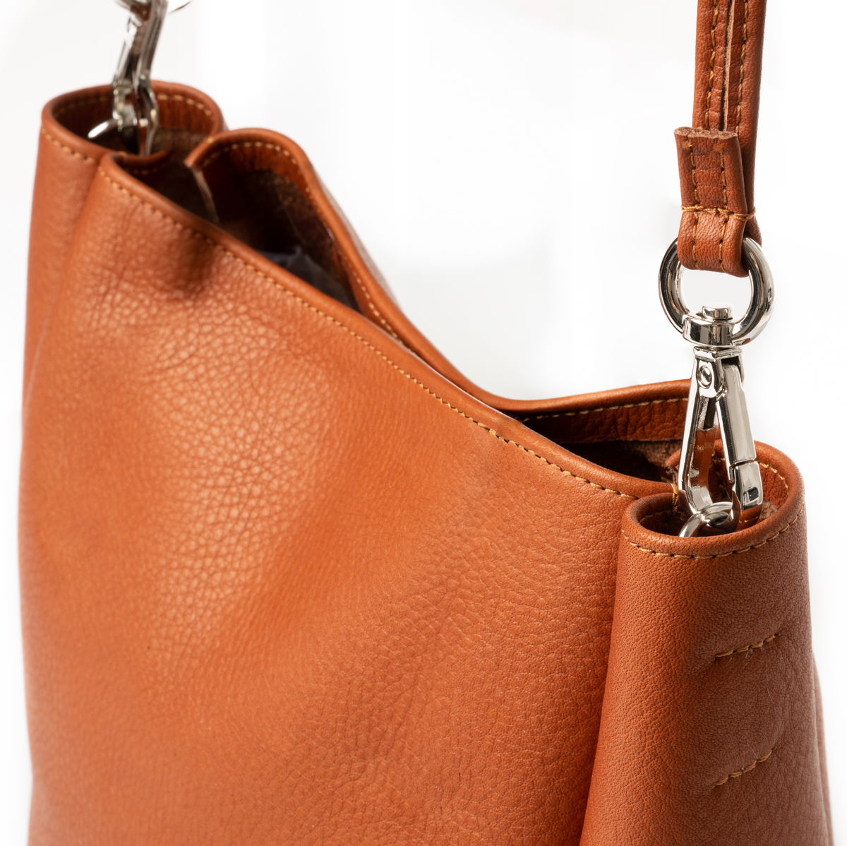 Nahaufnahme einer eleganten Ledertasche in braun-orangefarbenem Design mit silbernen Metallakzenten und einem verstellbaren Schultergurt.