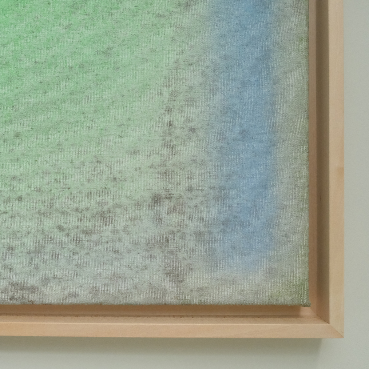 Ein Kunstwerk mit abstrakten Farben, dominierend in Grün und Blau, in einem Holzrahmen präsentiert. Das Bild zeigt einen weichen Übergang der Farben, die beruhigend wirken.