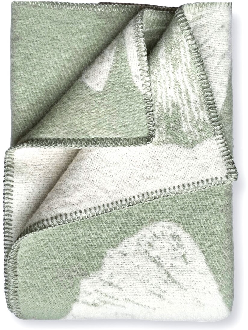 Bild einer gefalteten Decke mit Ginkgo-Muster in den Farben Grün und Creme, detailreich bestickt.