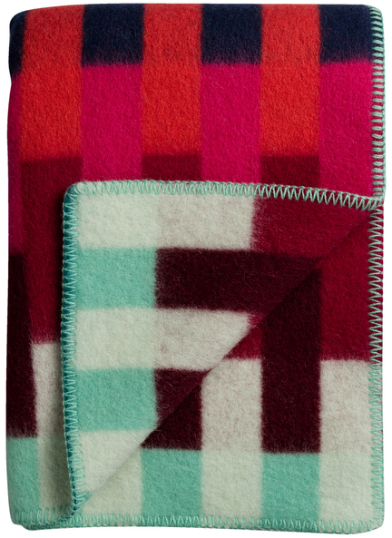 Lammwolldecke »ASMUND Bold« in rotem, blauen, grünen und weißen Farben mit geometrischem Muster, zusammengefaltet sichtbar auf weißem Hintergrund.