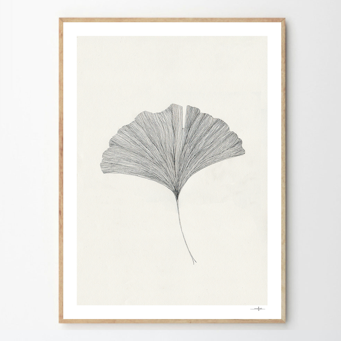 Ein minimalistisch gerahmter Kunstdruck zeigt ein Ginkgoblatt in Schwarz-Weiß. Das Blatt ist zentral auf einem hellen Hintergrund platziert, umgeben von einem schlichten Holzrahmen.