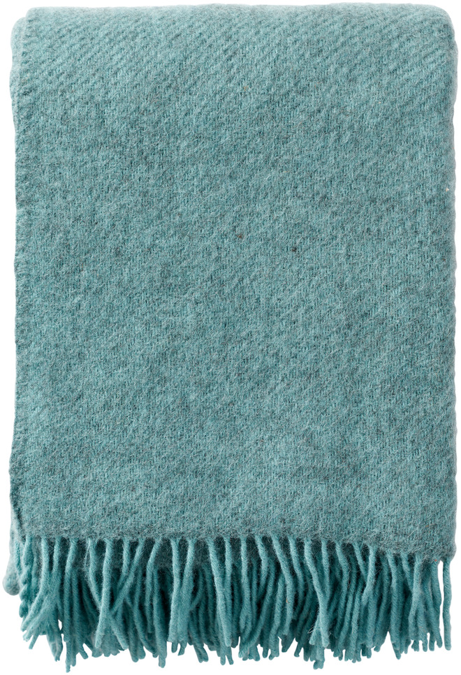 Eine flauschige, grün-blaue Woll-Decke mit Fransen, ideal für gemütliche Winterabende und dekorative Zwecke im Wohnzimmer.