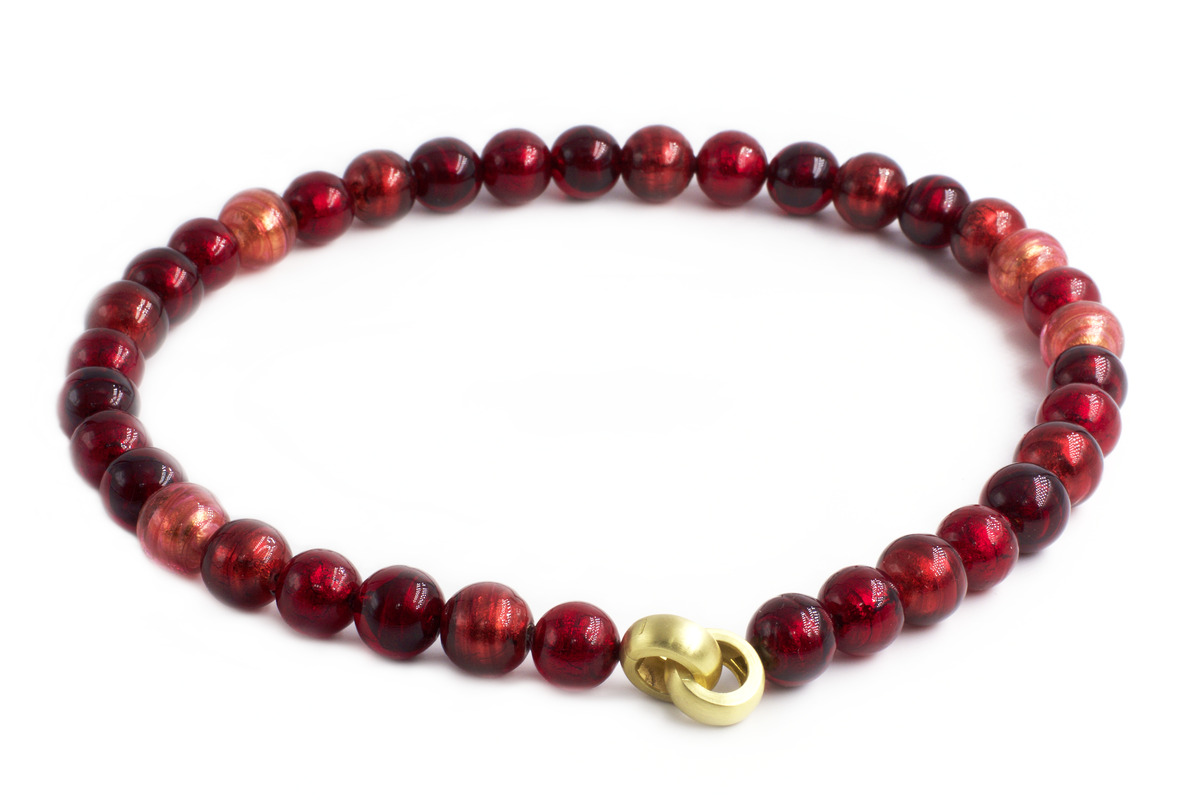 Ein elegantes Collier aus Muranoglas mit dem Namen »Venus« zeigt glänzende rote Glasperlen, die durch einen goldenen Verschluss miteinander verbunden sind. Es wirkt luxuriös und handgefertigt und eignet sich als Schmuckstück für besondere Anlässe.