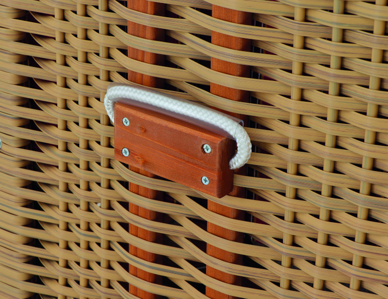 Nahaufnahme eines Gartenstrandkorbs »Tarent«. Die Rückseite besteht aus eng verflochtenem beigem und braunem Rattan und hat ein kleines rechteckiges Stück Holz, das als Griff mit einem weißen Seil befestigt ist.