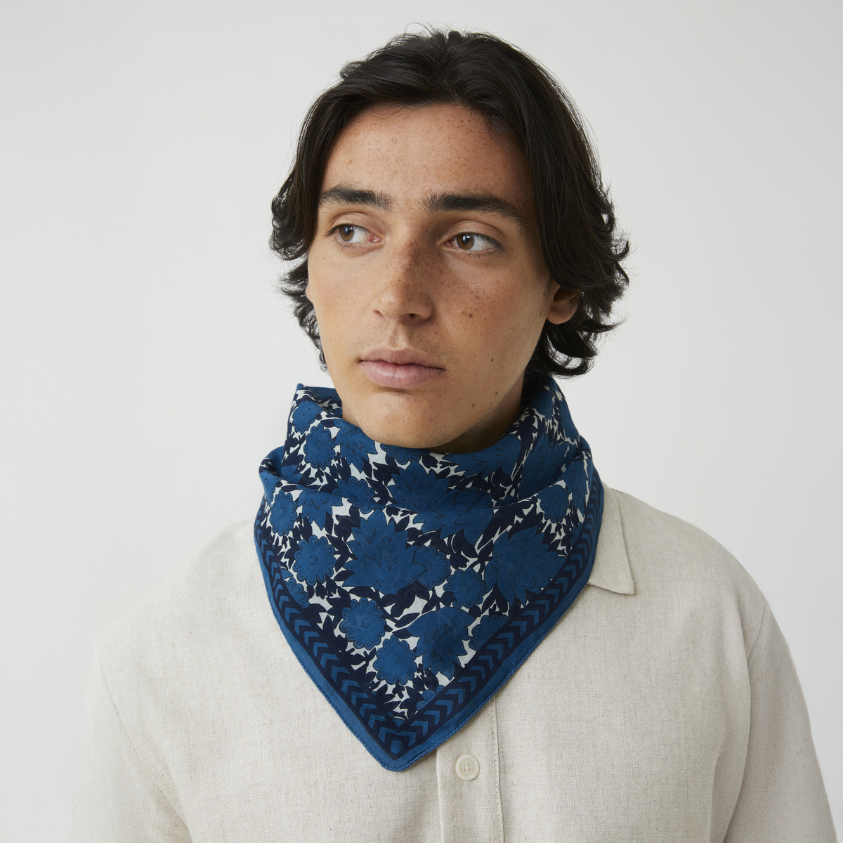 Baumwolltuch »No. 791« von MOISMONT aus 100 % Baumwolle, quadratisch 67 x 67 cm, mit zweifarbigem, von Hand gedrucktem Blumenmuster in Indigo- und Blautönen. Chevron-Bordüre, dezenter Marken-Schriftzug. Leicht, anschmiegsam und elegant.