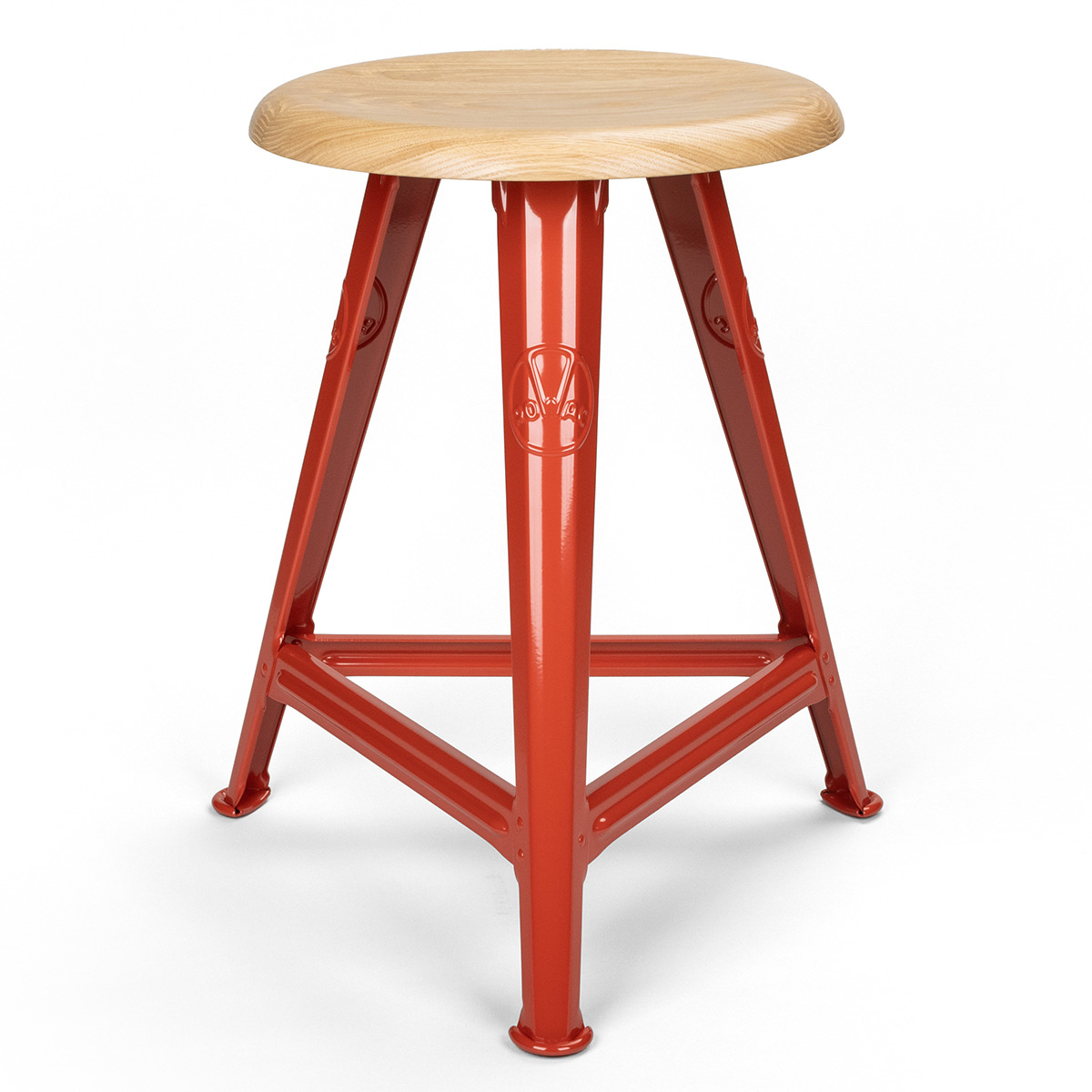 Ein Hocker mit einem runden, holzfarbenen Sitz und einem Gestell aus rotem Metall. Das Design ist schlicht und industriell, mit einem stabilen und minimalistischem Look.
