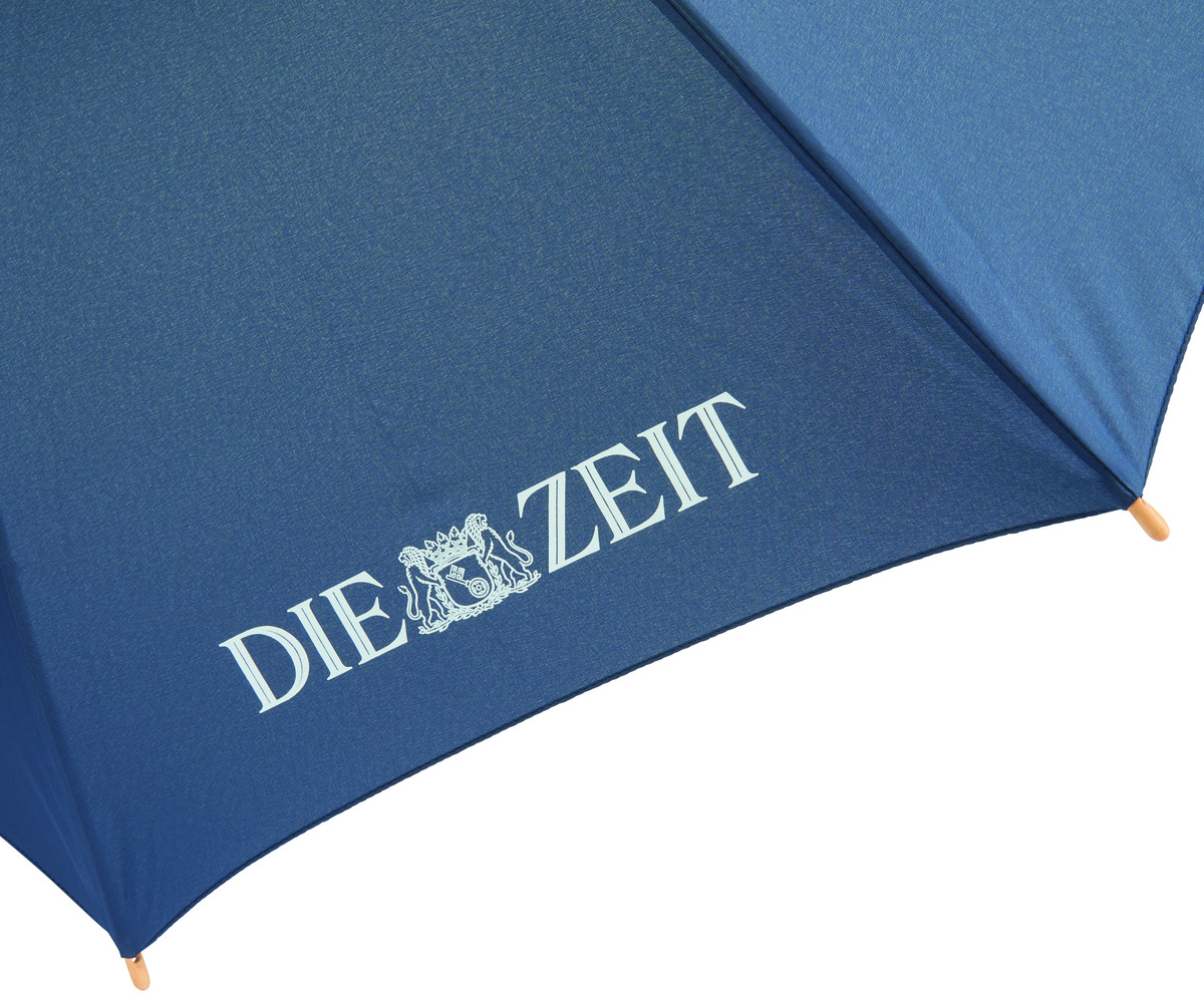 Blauer Regenschirm mit weißem Schriftzug 'Die ZEIT' und einem Emblem darunter.
