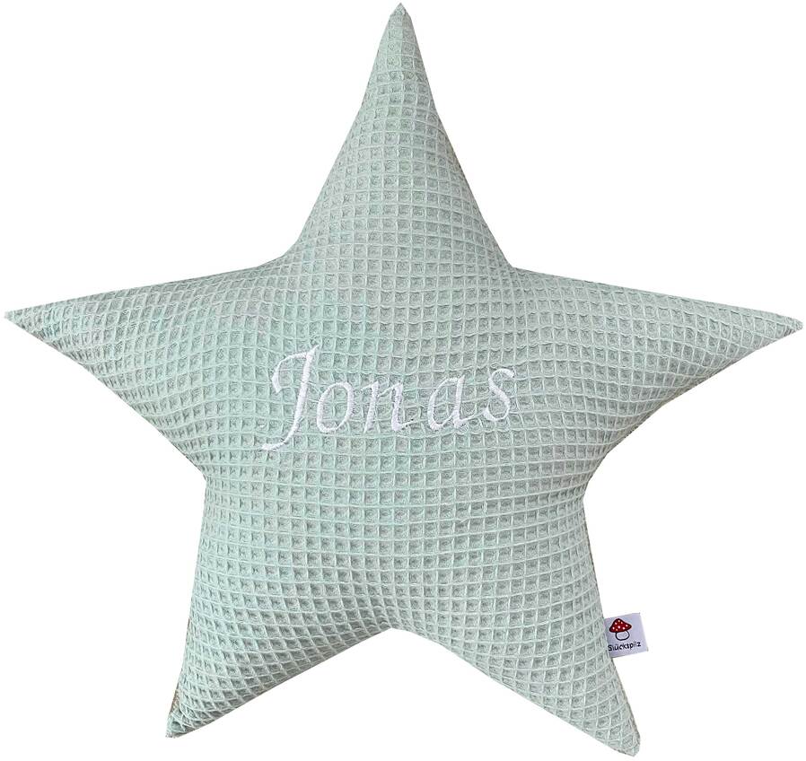 Ein weiches, sternförmiges Kissen mit der Aufschrift 'Jonas' in der Mitte, gestrickt in hellgrüner Farbe. Ideales personalisierbares Geschenk für Kinderzimmer oder als Dekoration.