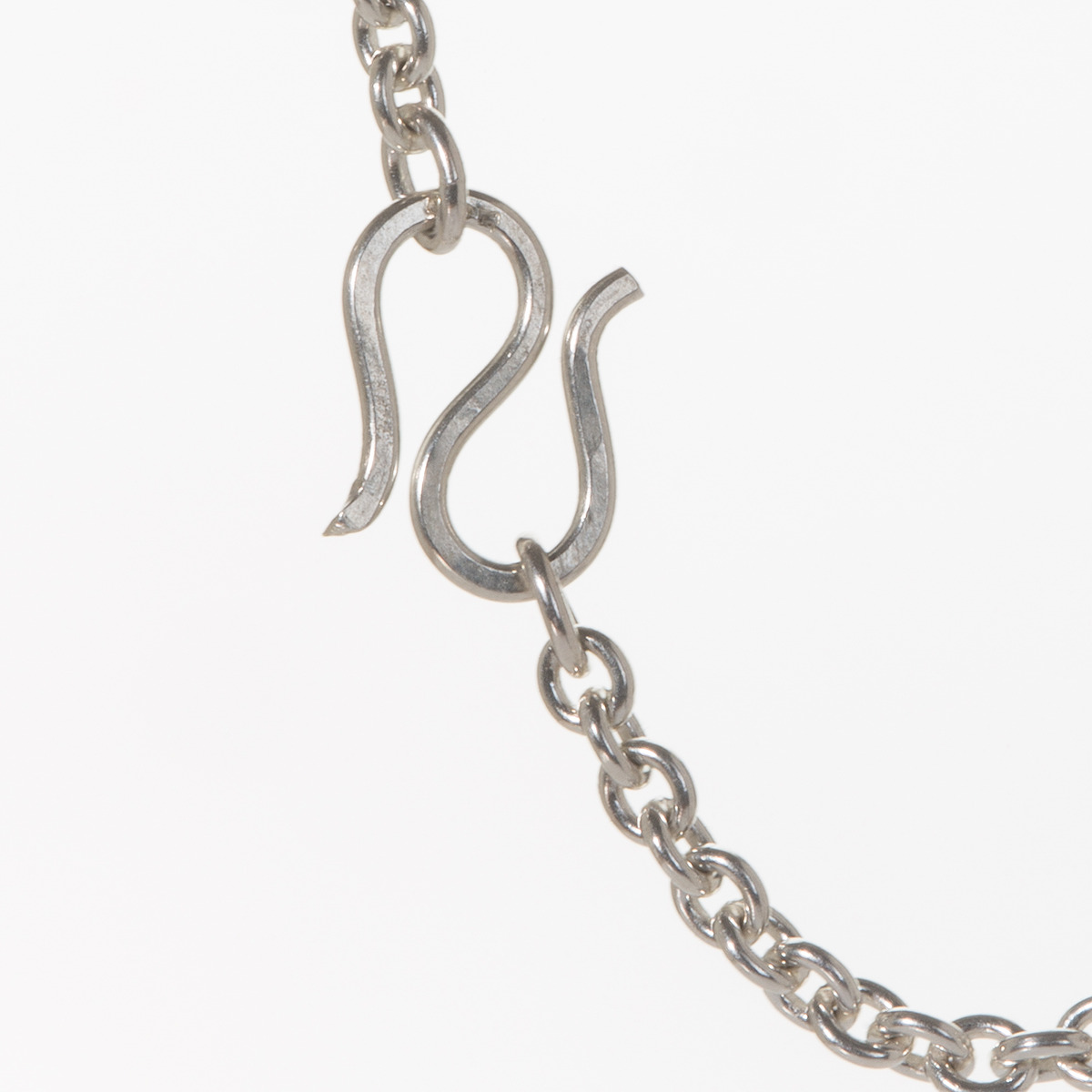 Detailansicht einer glänzenden Ankerkette aus massivem 925er Silber von Anke Gralfs. Sichtbar sind die ovalen, regelmäßigen Kettenglieder und der formschöne S-Haken-Verschluss. Die Kette liegt auf weißem Hintergrund und wirkt hochwertig und zeitlos elegant.