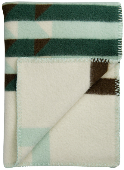 Lammwolldecke »KVAM« mit geometrischem Muster in den Farben Grün, Braun und Weiß. Die Decke ist gefaltet und die Ecke ist umgeschlagen, um die Rückseite zu zeigen.