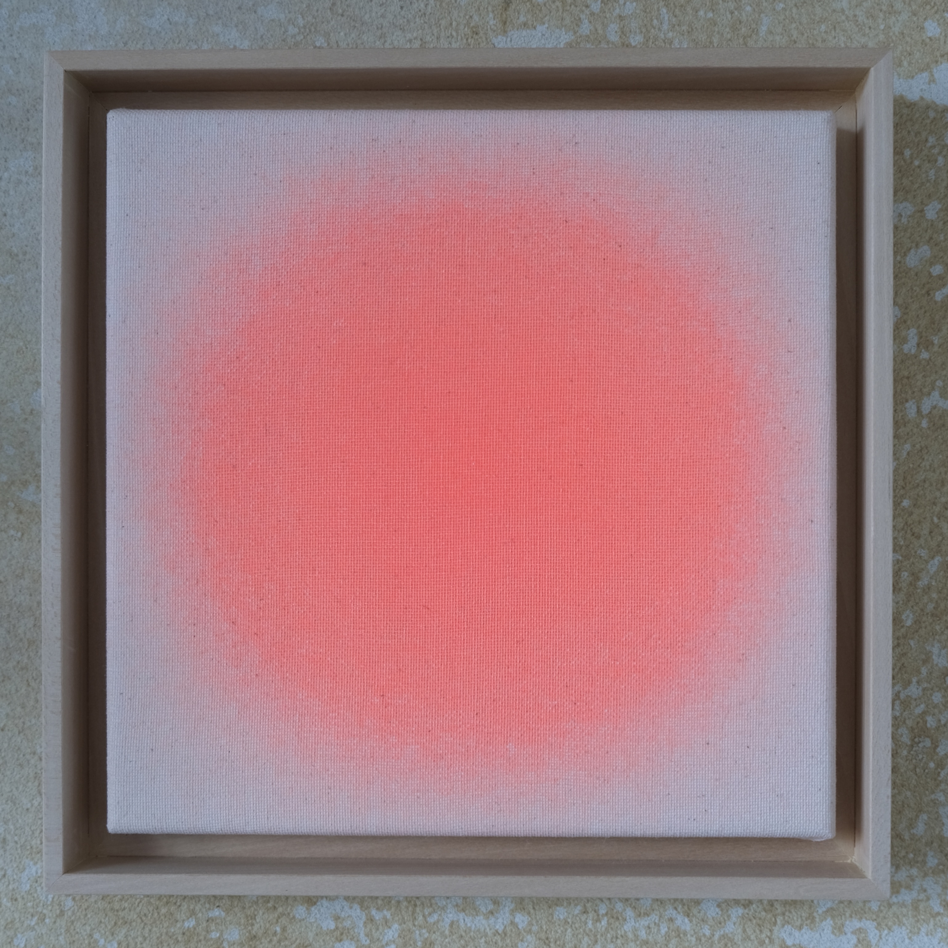Quadratisches Kunstwerk in hellem Lindenholzrahmen, mittig ein zarter Kreis in Apricot-Orange auf naturfarbener, unbehandelter Leinwand. Der apricotfarbene Farbverlauf wirkt wie ein sanfter, transparenter Nebel und hebt sich weich vom beigen Hintergrund ab. Das Bild strahlt Leichtigkeit und Ruhe aus.