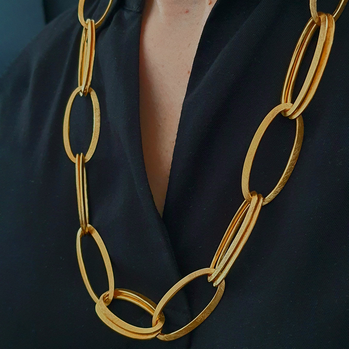 Nahaufnahme des feingoldplattierten Colliers »GRACE« von HML Berlin aus großen, ellipsenförmigen Gliedern an einem Hals über einem schwarzen Oberteil. Das Schmuckstück wirkt modern, hochwertig und stilvoll, ideal für besondere Anlässe.