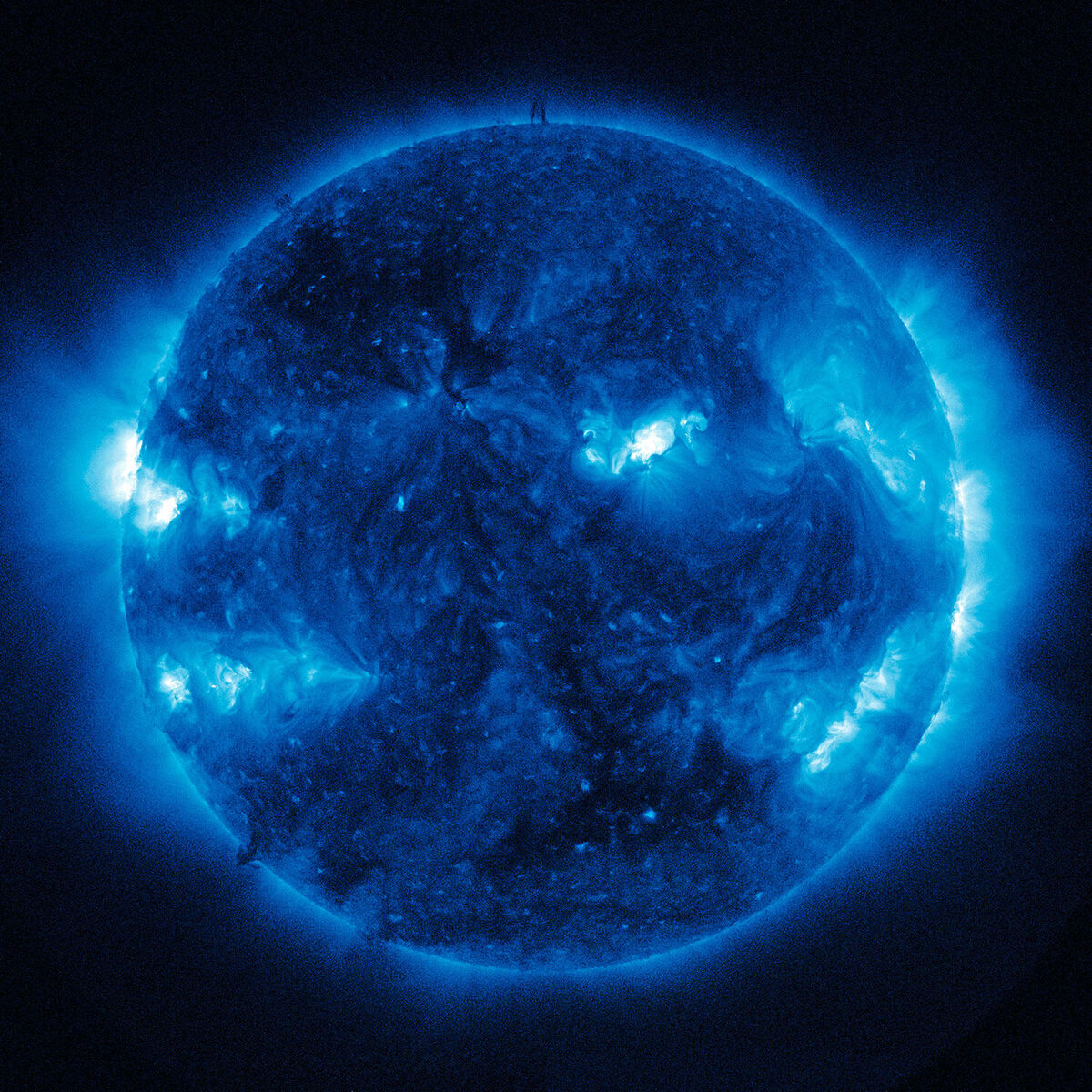 Ein modernes Kunstwerk von Katharina Sieverding aus dem Jahr 2017 zeigt ein blau leuchtendes Bild der Sonne aufgenommen von der NASA. Die kräftigen Blautöne und kontrastierenden Schwarzanteile erzeugen ein mystisches und faszinierendes Bild des Sonnensystems.