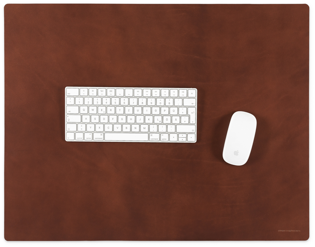 Diese Schreibtischunterlage in Cognac bietet eine elegante Lederoberfläche, die optimalen Schutz und Stil für Ihre Büroumgebung gewährleistet. Sie ist mit einer weißen Tastatur und einer weißen Maus darauf abgebildet, perfekt für das Homeoffice oder den professionellen Arbeitsplatz.