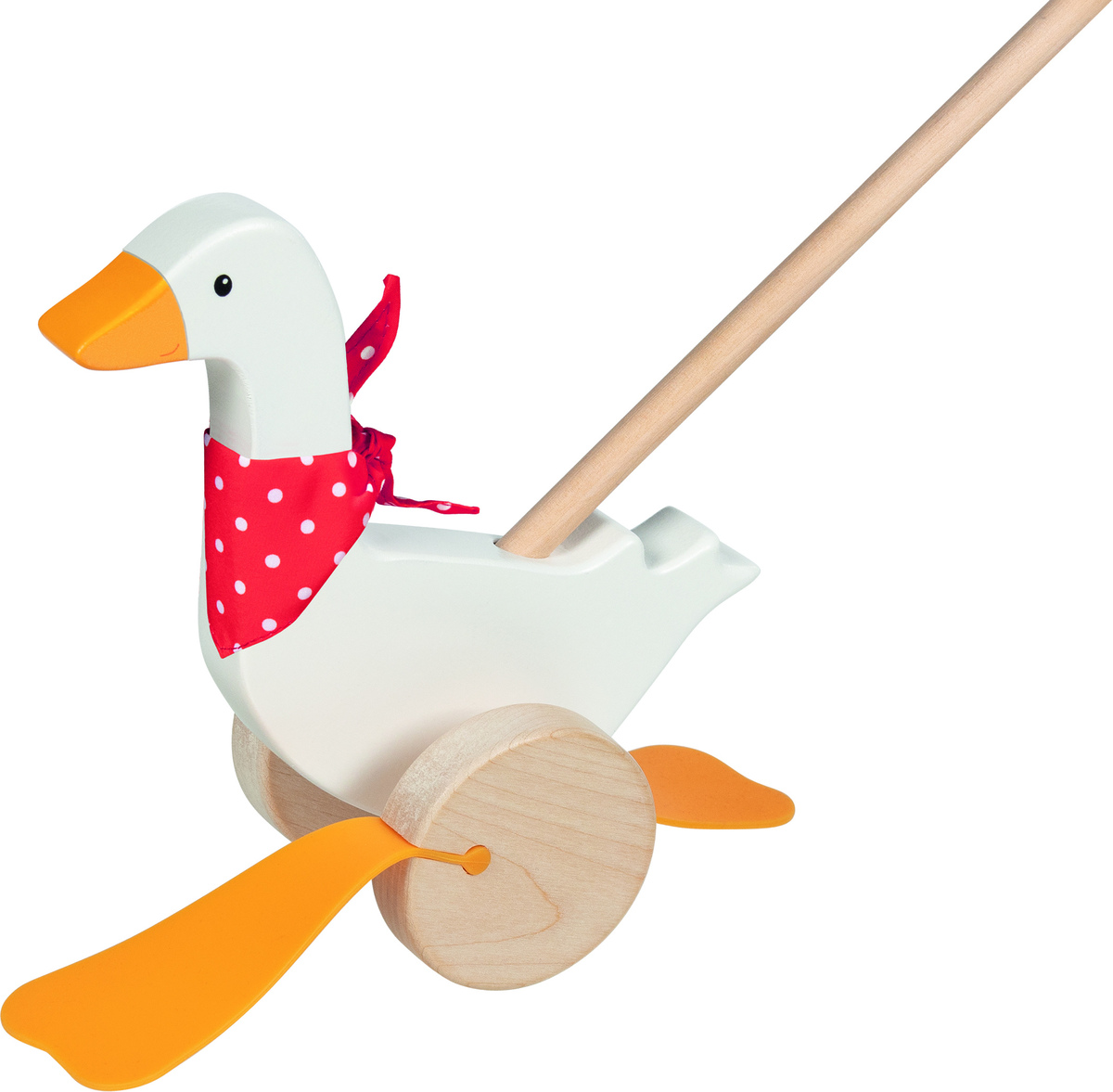 Das Bild zeigt das Schiebetier »Gans Bertha«. Es handelt sich um ein Holzspielzeug in Form einer weißen Gans mit einem roten Halstuch und orangenen Beinen. Die Gans steht auf zwei Holzrädern und ist mit einem Holzstab verbunden.