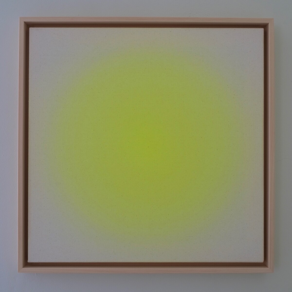 Ein Kunstwerk der ZEIT Sonderedition mit dem Titel 'Sorbet Lemon'. Es ist 50x50 cm groß und zeigt eine minimalistische, abstrakte Darstellung in einem Holzbilderrahmen. Die Leinwand ist überwiegend weiß mit einem zentralen gelben Farbkreis.