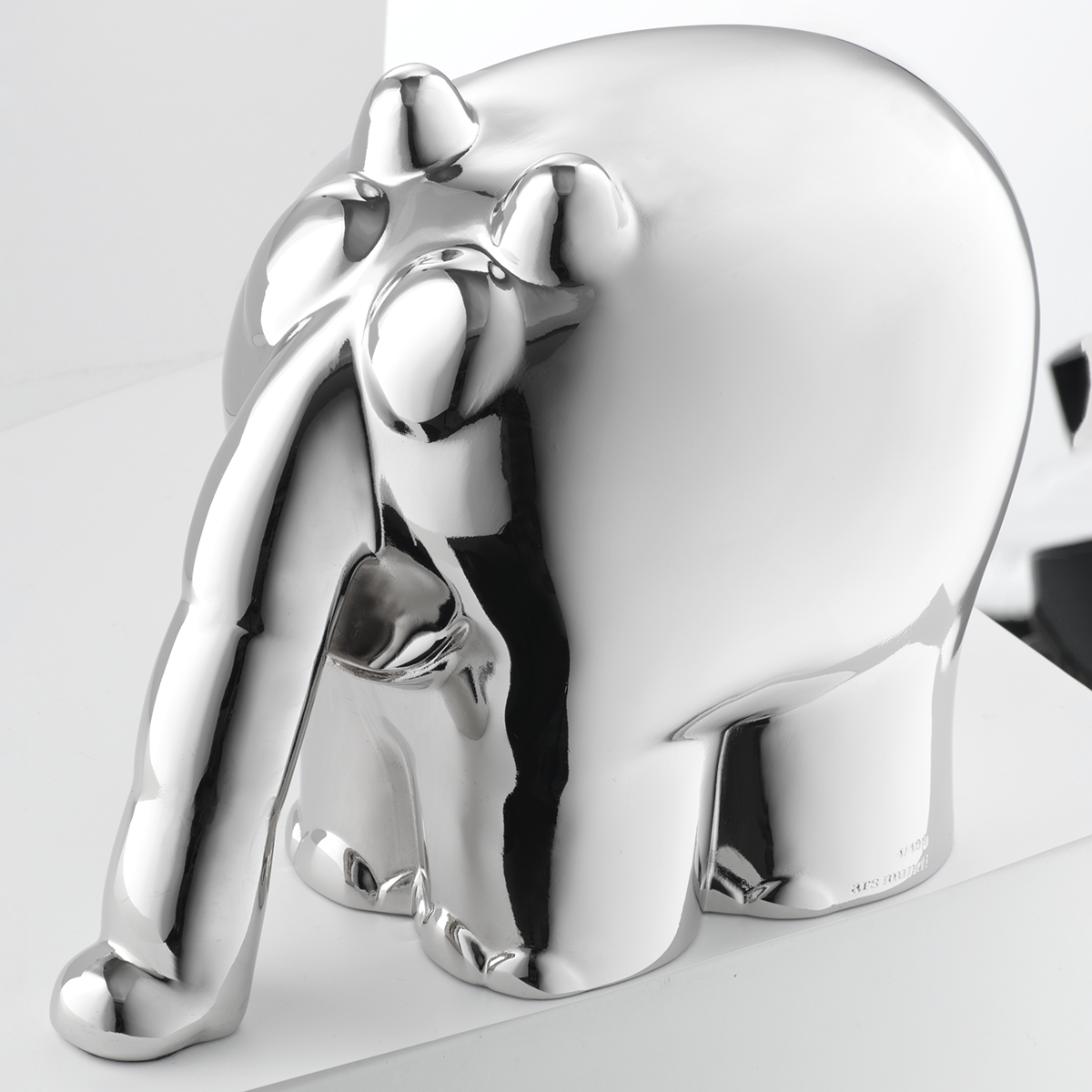 Metallisch-silberne Skulptur eines stilisierten, Comic-artigen Elefanten namens "Ottifant", entworfen von Otto Waalkes. Die Oberfläche glänzt stark, das Objekt steht auf einer hellen, glatten Fläche. Details wie Beine, Rüssel und Augen sind abstrahiert dargestellt.