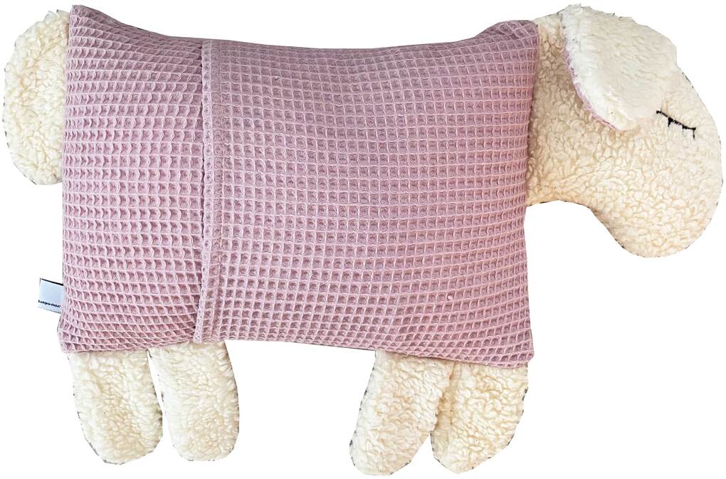 Ein weiches Kuscheltierkissen in der Form eines Schafs mit rosa und weißem Plüsch.