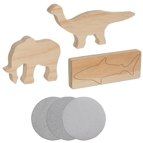 Schnitz-Set 'Tiere' zeigt drei holzgeschnitzte Tierformen – ein Dinosaurier, ein Elefant und ein Hai auf einem rechteckigen Holzstück. Drei graue Schleifpapiere sind ebenfalls enthalten.