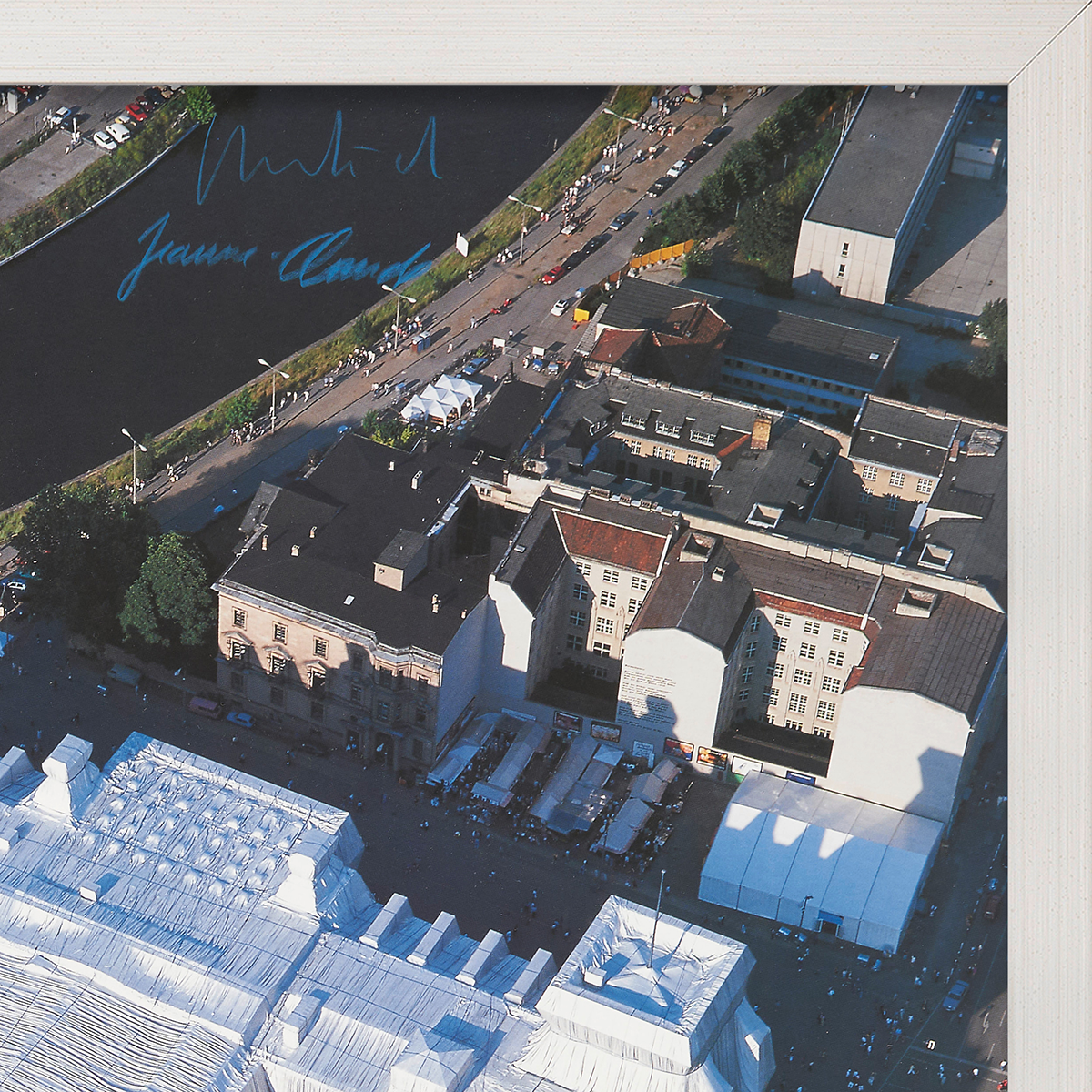 Luftaufnahme des Reichstags in Berlin, aus Westen nach Osten fotografiert. Zu sehen sind umliegende Gebäude, Straßen und Grünflächen. Eine gerahmte Fotografie, geeignet für Kunstsammler und Geschichtsinteressierte.