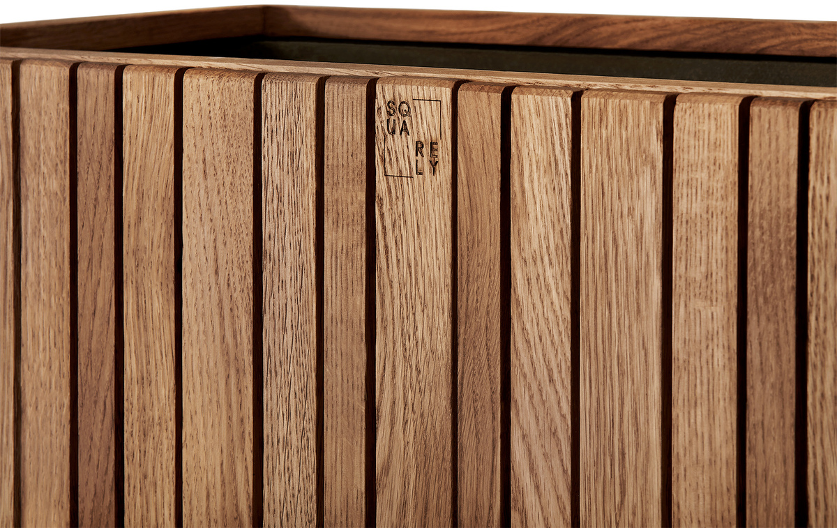 Das Bild zeigt das Pflanzgefäß »GrowWIDE«, das aus Holz gefertigt ist und eine natürliche Holzoptik aufweist. Es ist rechteckig mit vertikalen Streifenmuster.