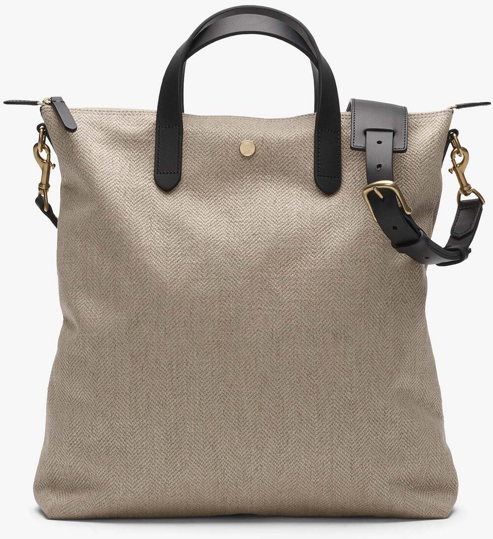 Eine beigen Shopper-Tasche von MISMO mit schwarzen Ledergriffen und goldenen Akzenten, ideal für stilvolle und hochwertige Nutzung.