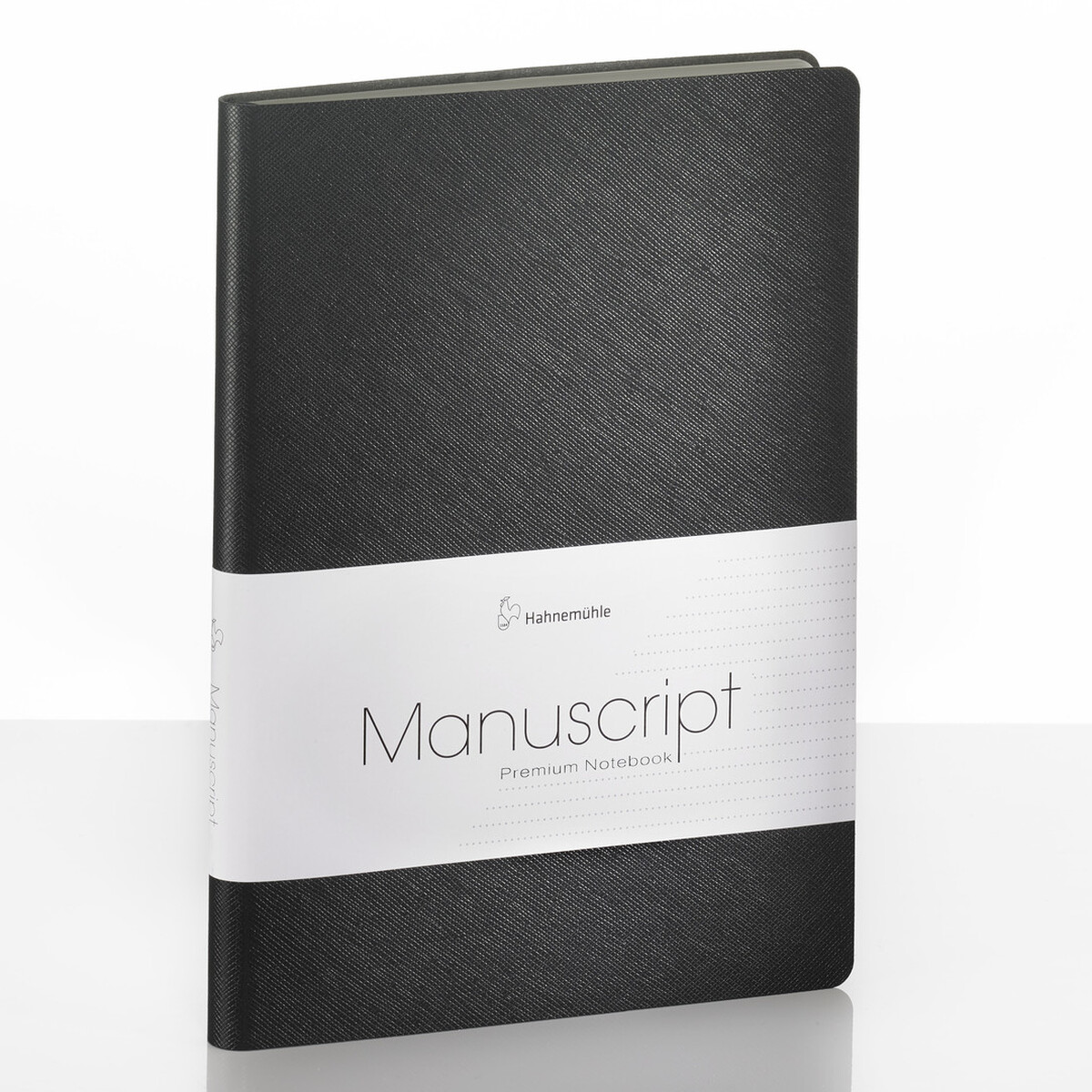 Ein schwarzes Notizbuch im DIN-A5-Format mit der Aufschrift »Manuscript«. Das Buch hat ein schlichtes, professionelles Design und befindet sich auf einer reflektierenden weißen Oberfläche.