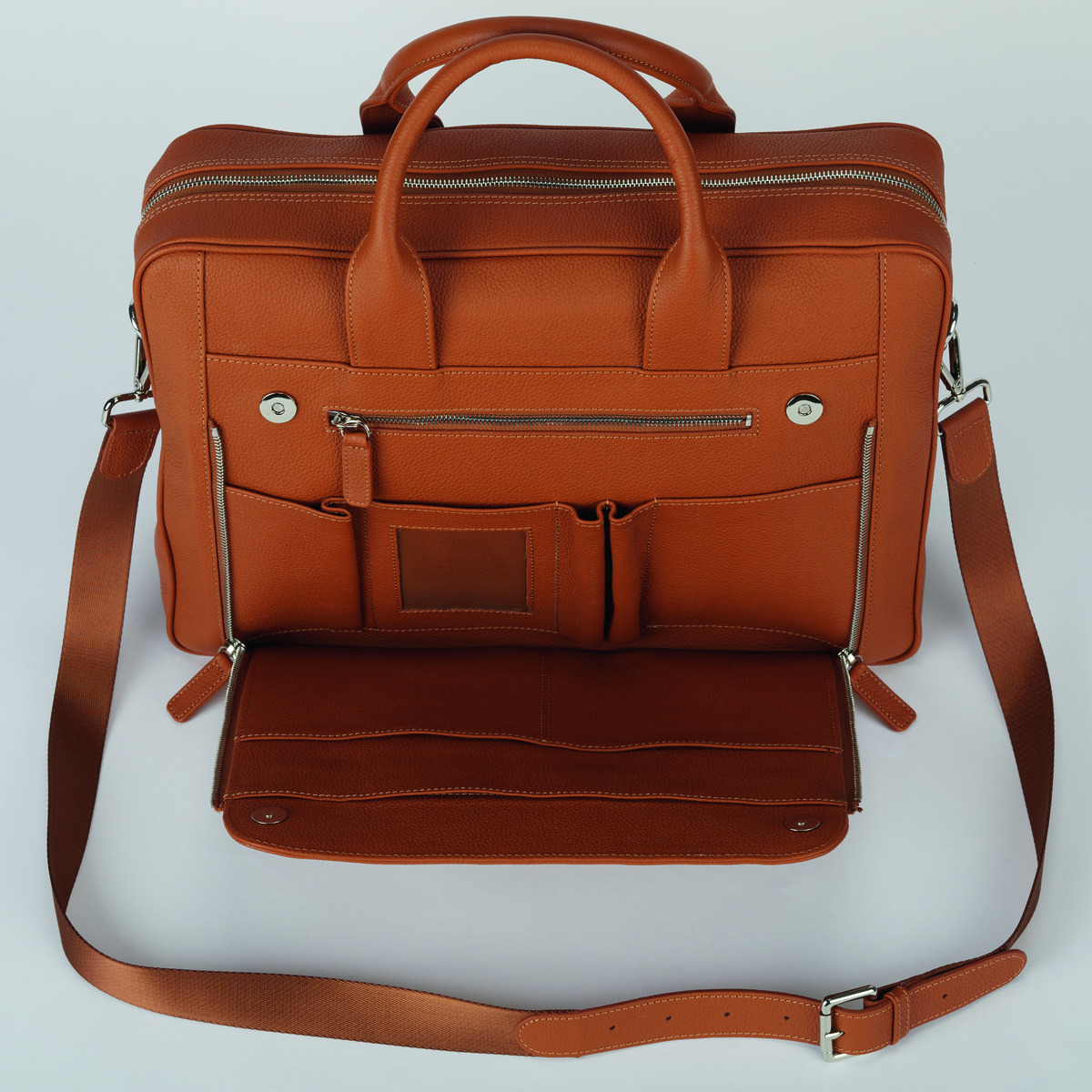 Eine orangene Business-Tasche aus Leder mit mehreren Reißverschlusstaschen, Schulterriemen und Tragegriff. Geeignet für Laptop und Bürobedarf.