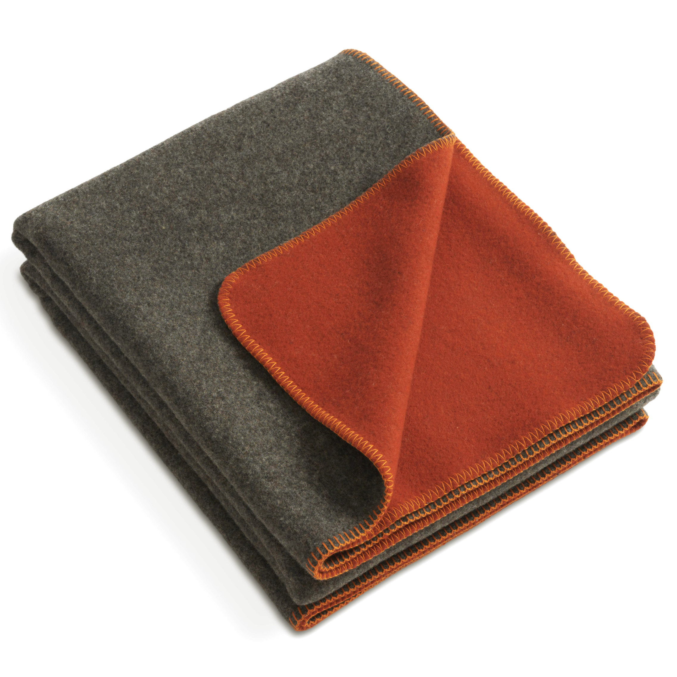 Gefaltete Merinodecke namens »FireSideMoon« mit einer Seite in Grauton und der anderen Seite in kräftigem Orange, kontrastierende Ziernaht, aus weichem Wollmaterial, geeignet als Wohn- oder Kuscheldecke.
