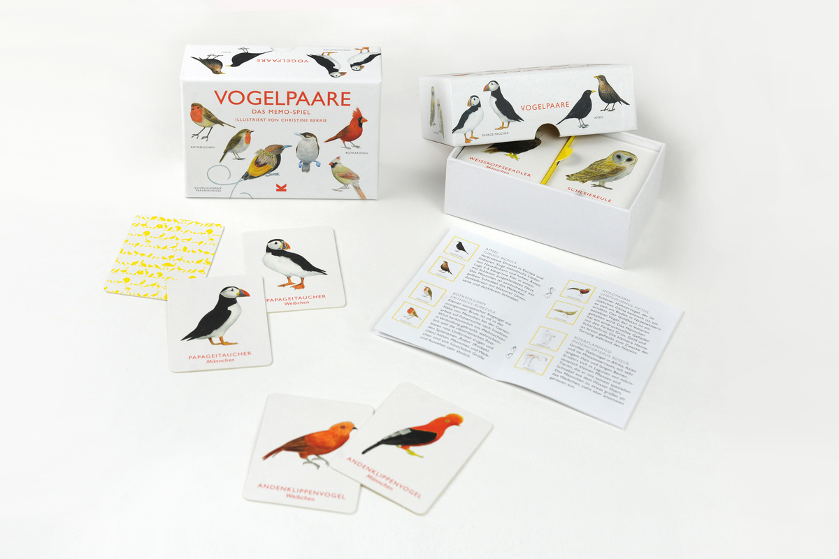 Memo-Spiel »Vogelpaare« mit Karten, die verschiedene Vogelarten zeigen, in einer weißen Box mit roten und schwarzen Aufschriften. Enthalten sind auch Spielanleitungen und eine kleinere gelbe Karte.
