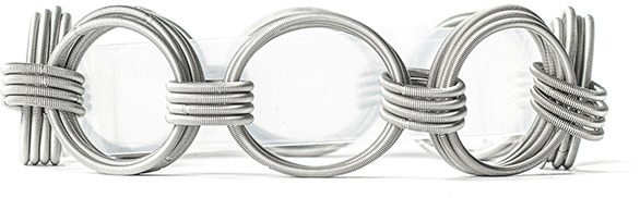 Ein silbernes Armband mit mehreren, miteinander verbundenen Kreisen, die durch verknotete Drahtdetails verziert sind. Das Design wirkt elegant und vintage-inspiriert.