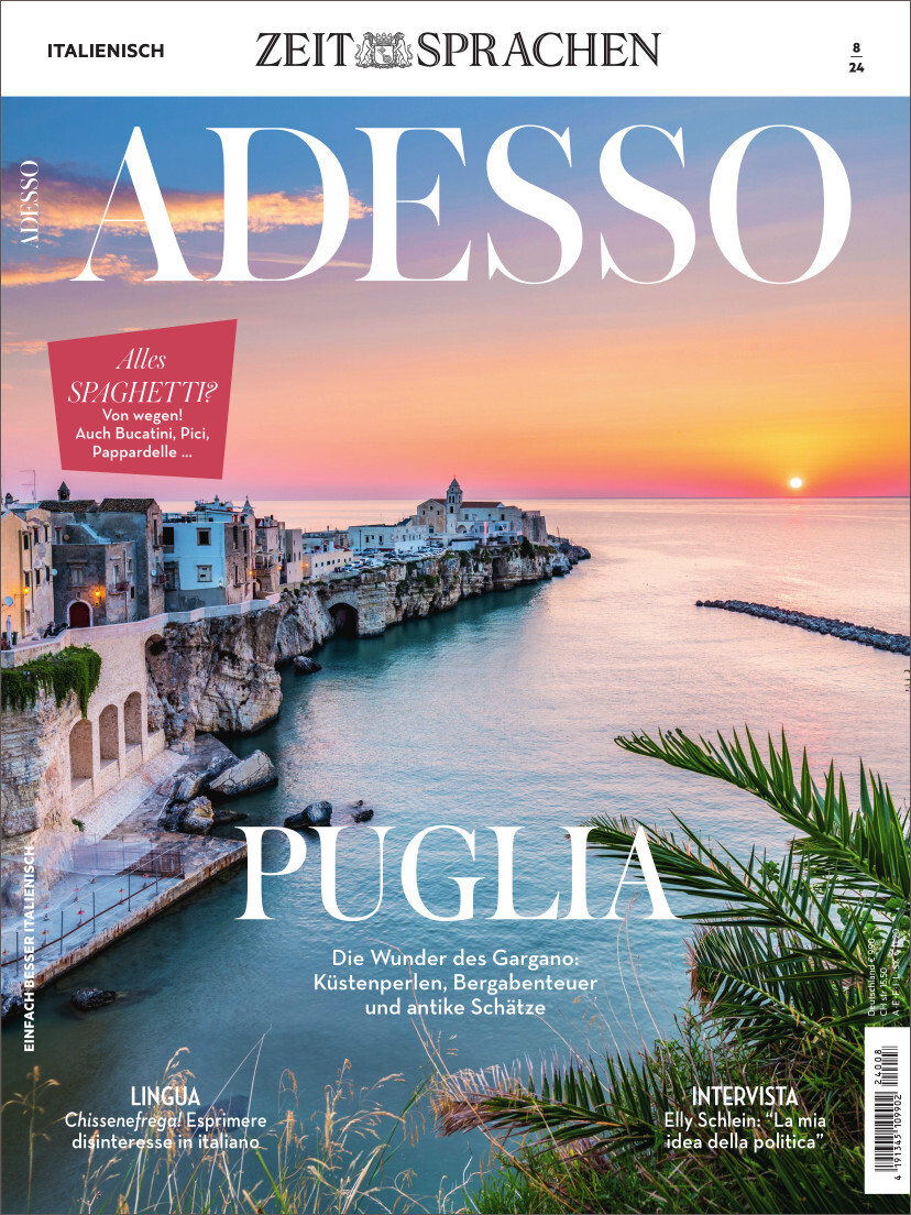 Das Cover des Magazins Adesso Ausgabe 08/2024 zeigt die malerische Küstenlandschaft von Puglia in Italien bei Sonnenuntergang. Im Vordergrund sind Palmen und das Meer zu sehen, während die Küste im Hintergrund von historischen Gebäuden gesäumt ist. Texte auf dem Cover umfassen Themen wie Sprachen, Kultur und Reisen.