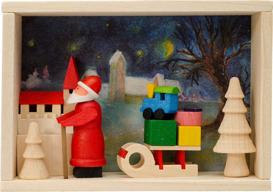 Ein handgemachtes Holzspielzeug zeigt einen Weihnachtsmann mit Schlitten vor einem märchenhaften Hintergrund. Der Weihnachtsmann in roten Kleidern steht neben einem Schlitten, der mit bunten Geschenken beladen ist. Links und rechts vom Weihnachtsmann befinden sich hölzerne Bäume und Häuser, vor einem winterlichen, nächtlichen Hintergrund.