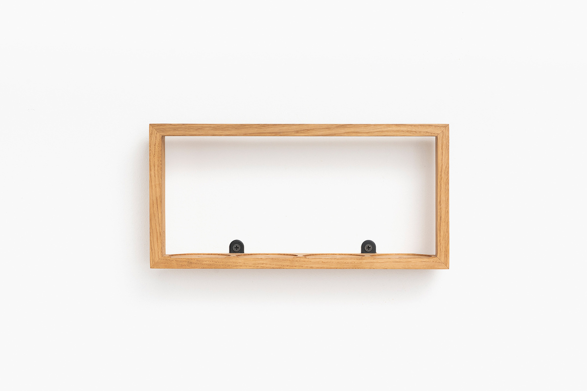 Ein minimalistisches Gewürzregal aus Holz. Es hat eine rechteckige Form und ist an der Wand montiert. Das Regal bietet Platz für Gewürze oder andere kleine Kücheutensilien. Die Farbe des Holzes ist naturbelassen und die Wandhalterungen sind schwarz.