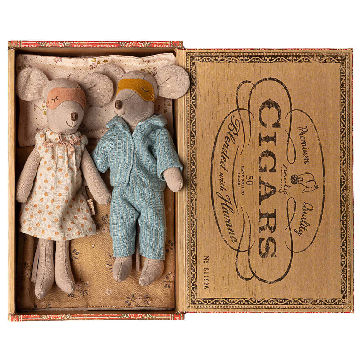 Zwei Stoffmäuse, dargestellt als Mama und Papa, liegen in einer offenen Zigarrenkiste. Die Mäuse tragen Schlafkleidung und Schlafmasken, sie liegen auf gemusterten Kissen und einer Decke. Die Darstellung vermittelt eine gemütliche und nostalgische Atmosphäre, geeignet als Geschenk oder Dekoration für Kinder.
